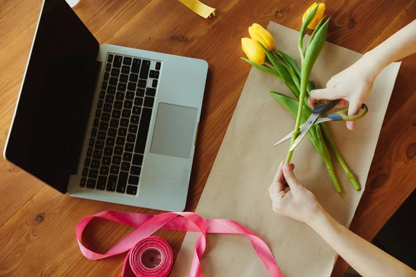 Kwiaciarnia w pracy: kobieta pokazuje, jak zrobić bukiet z tulipanami, pracy w domu koncepcji, widok z góry — Zdjęcie stockowe