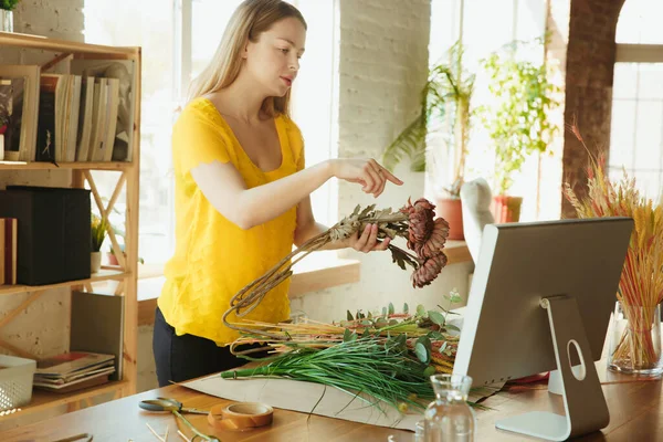 Floristería en el trabajo: la mujer muestra cómo hacer ramo, trabajar en el concepto de casa, la elección de las plantas para la composición — Foto de Stock