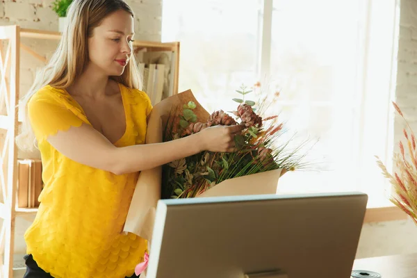 Blommor pÃ ¥jobbet: kvinna visar hur man gÃ ¶ r bukett, arbetar hemma koncept, visar resultatet — Stockfoto