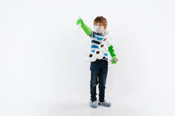 Kis kaukázusi fiú, mint harcos a koronavírus világjárvány ellen, arcmaszkkal, hőmérővel, fertőtlenítővel és vécépapírral. — Stock Fotó