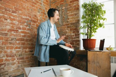 Kafkasyalı müzisyen evdeki online konser sırasında el davulu çalıyor tecrit edilmiş ve karantinaya alınmış, doğaçlama