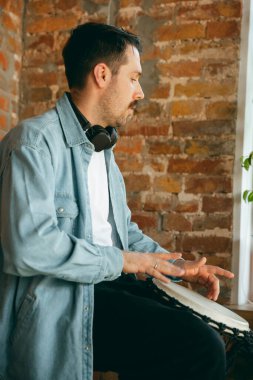 Kafkasyalı müzisyen evdeki online konser sırasında davul çalıyor tecrit edilmiş ve karantinaya alınmış, doğaçlama ilham verilmiş.