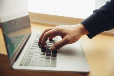 Bir iş belgesini daktilo eden erkek parmaklarının yakın plan görüntüsü, dizüstü bilgisayarda not ya da arama anahtarı