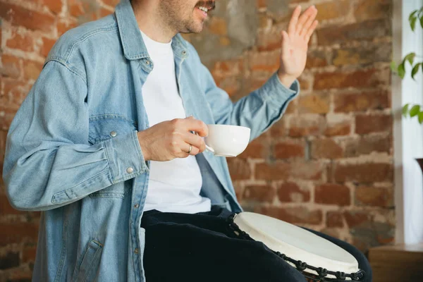 Vit musiker spelar hand trumma under online-konsert hemma isolerad och i karantän, hälsning band och kaffe dricka — Stockfoto