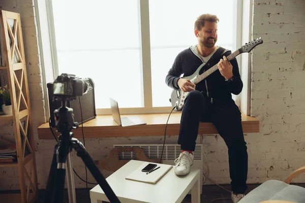 Kaukasischer Musiker spielt Gitarre bei Online-Konzert zu Hause isoliert und unter Quarantäne, fröhlich improvisiert — Stockfoto