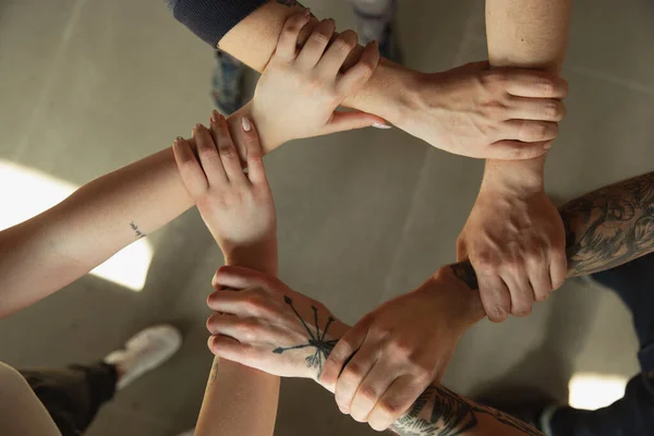 Primer plano de las manos caucásicas masculinas y femeninas, cubriéndose mutuamente, equipo, amistad, negocios — Foto de Stock