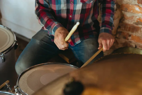 Músico caucasiano tocando bateria durante concerto online com a banda em casa isolado e em quarentena, inspirado improvisando, close-up — Fotografia de Stock