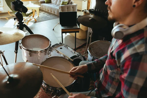 Músico caucasiano tocando bateria durante concerto online com a banda em casa isolado e em quarentena, inspirado improvisando, close-up — Fotografia de Stock