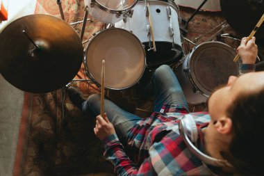 Kafkasyalı müzisyen, grupla çevrimiçi konser sırasında davul çalıyor. İzole edilmiş, karantinaya alınmış, ilham verici doğaçlama, yakın çekim.