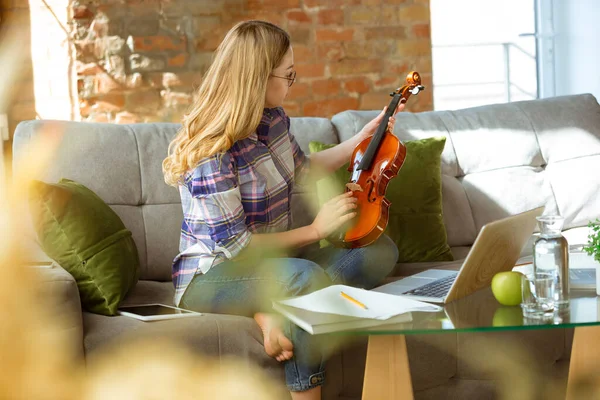 Mujer joven estudiando en casa durante cursos en línea o información gratuita por sí misma, tocando el violín, improvisando — Foto de Stock