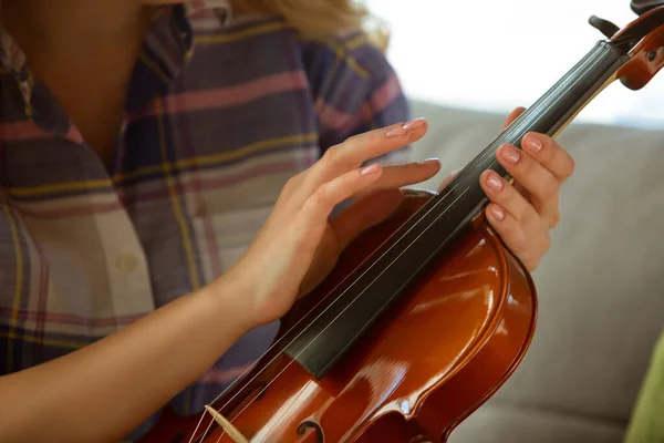 Jeune femme étudiant à la maison pendant les cours en ligne ou des informations gratuites par elle-même, prise de vue rapprochée du violon — Photo