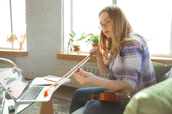 Ung kvinna studerar hemma under online-kurser eller gratis information själv, spela fiol, improvisera — Stockfoto