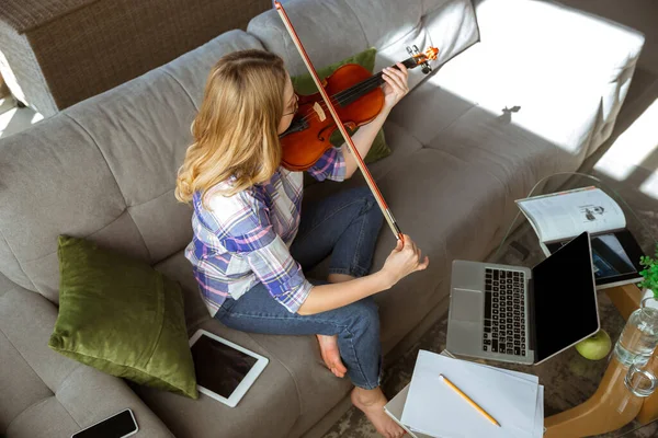Νεαρή γυναίκα που σπουδάζει στο σπίτι κατά τη διάρκεια online μαθημάτων ή δωρεάν πληροφορίες από μόνη της, παίζει βιολί, αυτοσχεδιάζει — Φωτογραφία Αρχείου