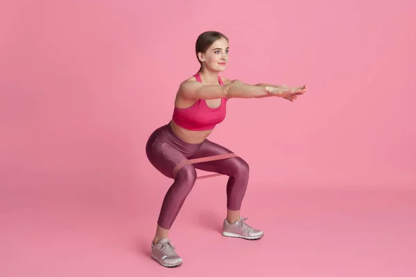 Beautiful young female athlete practicing on pink studio background, monochrome portrait — Stock Photo, Image