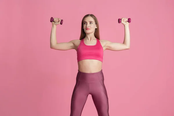 Όμορφη νεαρή αθλήτρια προπονείται σε ροζ φόντο στούντιο, μονόχρωμο πορτρέτο — Φωτογραφία Αρχείου
