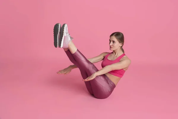 Hermosa joven atleta practicando sobre fondo de estudio rosa, retrato monocromo —  Fotos de Stock