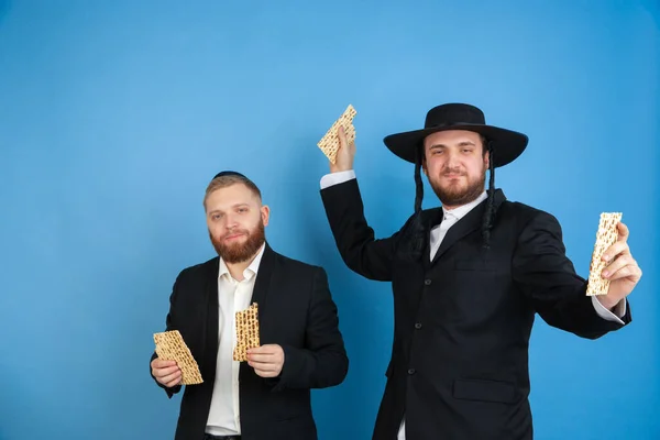 Portrait of a young orthodox jewish men isolated on blue studio background, meeting the Passover — Stock Photo, Image