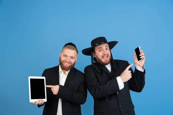 Portrait of a young orthodox jewish men isolated on blue studio background, meeting the Passover, winners — Stock Photo, Image