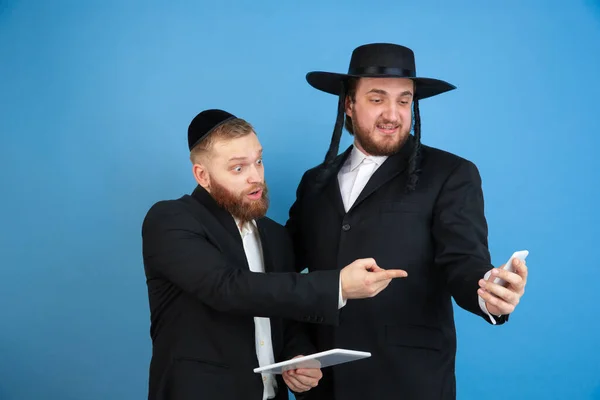 Portret van een jonge orthodoxe joodse mannen geïsoleerd op een blauwe studioachtergrond, die het Pascha ontmoetten, verbaasd — Stockfoto
