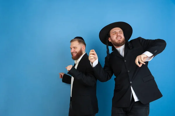 Porträtt av en ung ortodox jude män isolerade på blå studio bakgrund, möte påsk — Stockfoto