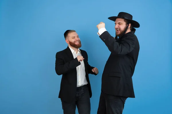 Portrait of a young orthodox jewish men isolated on blue studio background, meeting the Passover — Stock Photo, Image