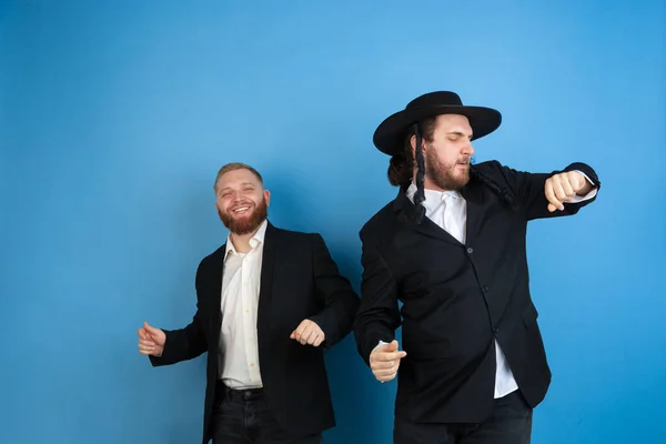 Portrait of a young orthodox jewish men isolated on blue studio background, meeting the Passover — Stock Photo, Image