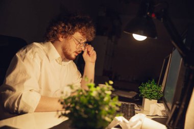 Coronavirus ya da COVID-19 karantinasında tek başına çalışan bir adam gece geç saatlere kadar kalıyor.