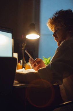 Coronavirus ya da COVID-19 karantinasında tek başına çalışan bir adam gece geç saatlere kadar kalıyor.