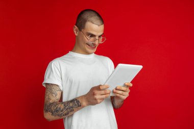 Kırmızı stüdyo arka planında beyaz erkek portresi - duygusal ve anlamlı