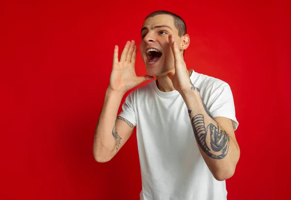 Branco jovem homem retrato sobre vermelho estúdio fundo, emotinal e expressivo — Fotografia de Stock