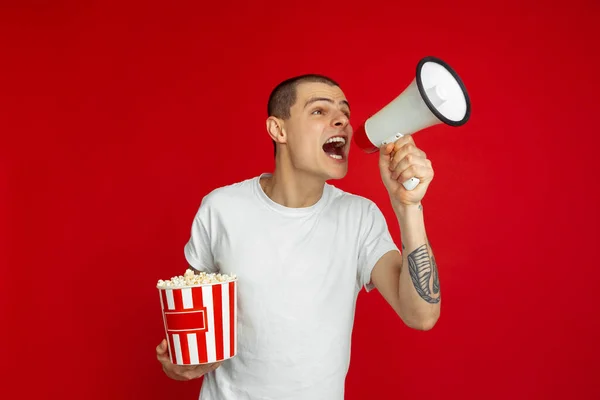 Caucasian young mans portrait on red studio background, emotinal and expressive, cinema concept — Stock Photo, Image