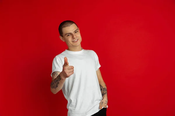 Branco jovem homem retrato sobre vermelho estúdio fundo, emotinal e expressivo — Fotografia de Stock