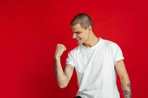 Branco jovem homem retrato sobre vermelho estúdio fundo, emotinal e expressivo — Fotografia de Stock