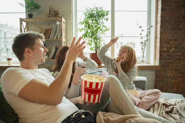 Familia pasar un buen tiempo juntos en casa, se ve feliz y alegre, viendo la televisión — Foto de Stock