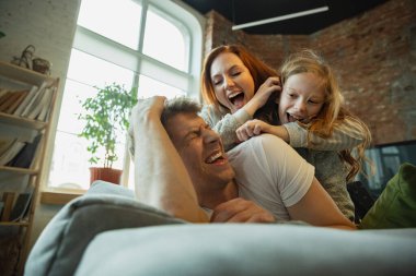 Aile evde birlikte güzel vakit geçiriyor, mutlu ve neşeli görünüyor, birlikte yatıyorlar.