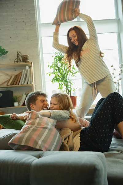 Familie brengen leuke tijd samen thuis, ziet er gelukkig en vrolijk, vechten met kussens — Stockfoto