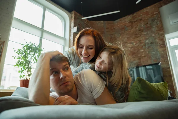 Familjen spenderar trevlig tid hemma, ser glad och glad ut, ligger ner tillsammans — Stockfoto