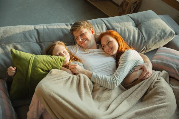 Η οικογένεια περνάει ωραία μαζί στο σπίτι, φαίνεται χαρούμενη και χαρούμενη, ξαπλωμένη μαζί. — Φωτογραφία Αρχείου