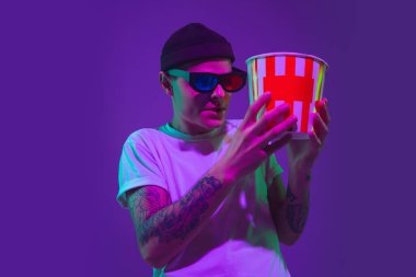 Beyaz adam portresi mor stüdyo arka planında neon ışığı altında izole edilmiş, sinema konsepti.