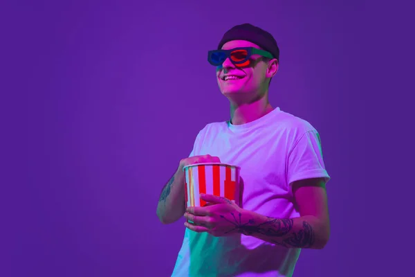 Kaukasiska mans porträtt isolerad på lila studio bakgrund i neon ljus, bio koncept — Stockfoto