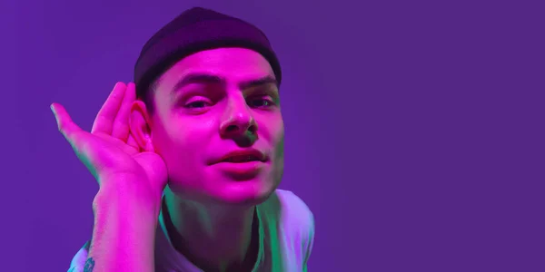 Портрет кавказьких майстрів ізольований на пурпуровій студії в неоновому світлі, флаєр — стокове фото