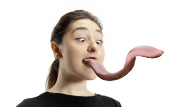 Gülümseyen kız ağzını açıyor ve beyaz arka planda izole edilmiş uzun, dev dilini gösteriyor. Deli ve çekici.