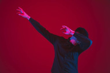 Beyaz adamın portresi kırmızı stüdyo arka planında izole edilmiş mor-mavi neon ışık, duygusal ve güzel