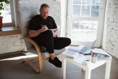 Genç adam internet kursları sırasında öğretmenlik, tıp fakültesi müdürü için evde okuyor.