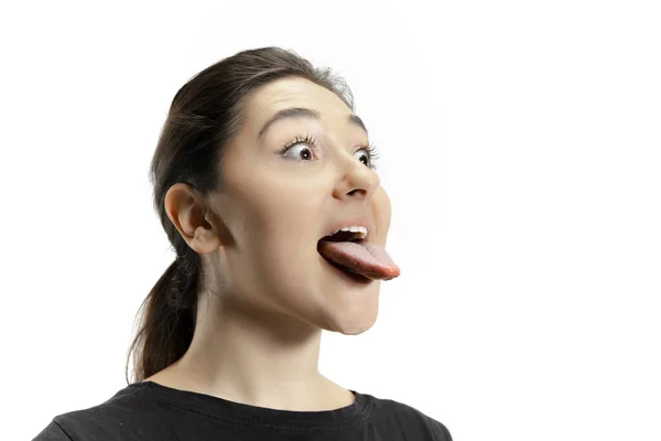 Ragazza sorridente che apre la bocca e mostra la lunga lingua gigante isolata su sfondo bianco, pazza e attratta — Foto Stock
