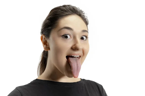 Ragazza sorridente che apre la bocca e mostra la lunga lingua gigante isolata su sfondo bianco, pazza e attratta — Foto Stock