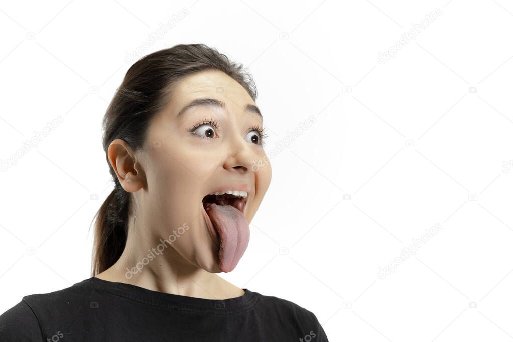 Smiling girl opening her mouth and showing the long big giant tongue isolated on white background, crazy and attracted