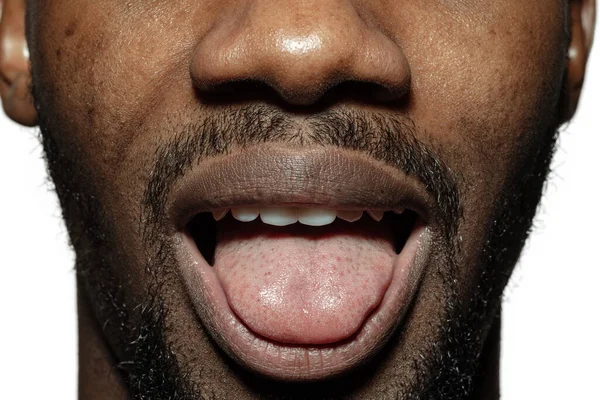Close-up van gezicht van mooie Afrikaans-Amerikaanse jongeman, focus op mond, steek tong uit — Stockfoto