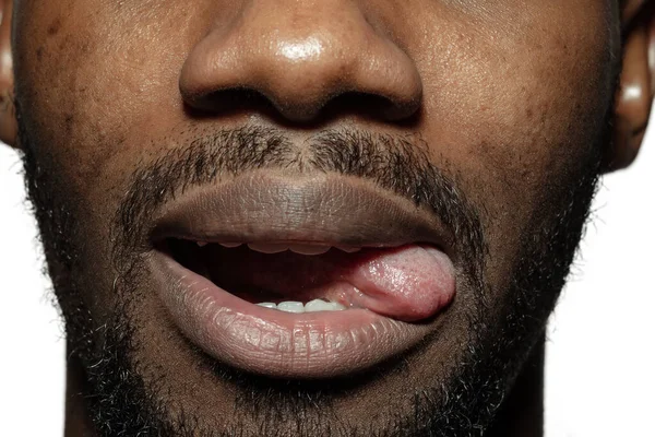 美しいアフリカ系アメリカ人の若者の顔を閉じて,口に焦点を当て,舌を突き出す — ストック写真