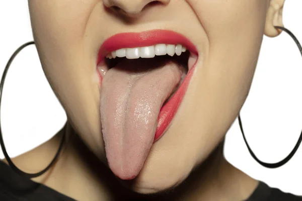 Χαμογελαστή κοπέλα που ανοίγει το στόμα της με κόκκινα χείλη και δείχνει τη μεγάλη τεράστια γλώσσα απομονωμένη σε λευκό φόντο, τρελή και ελκυστική, από κοντά — Φωτογραφία Αρχείου